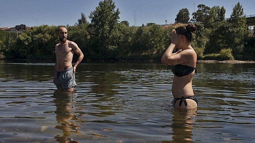 Dos personas se bañan en el Miño.