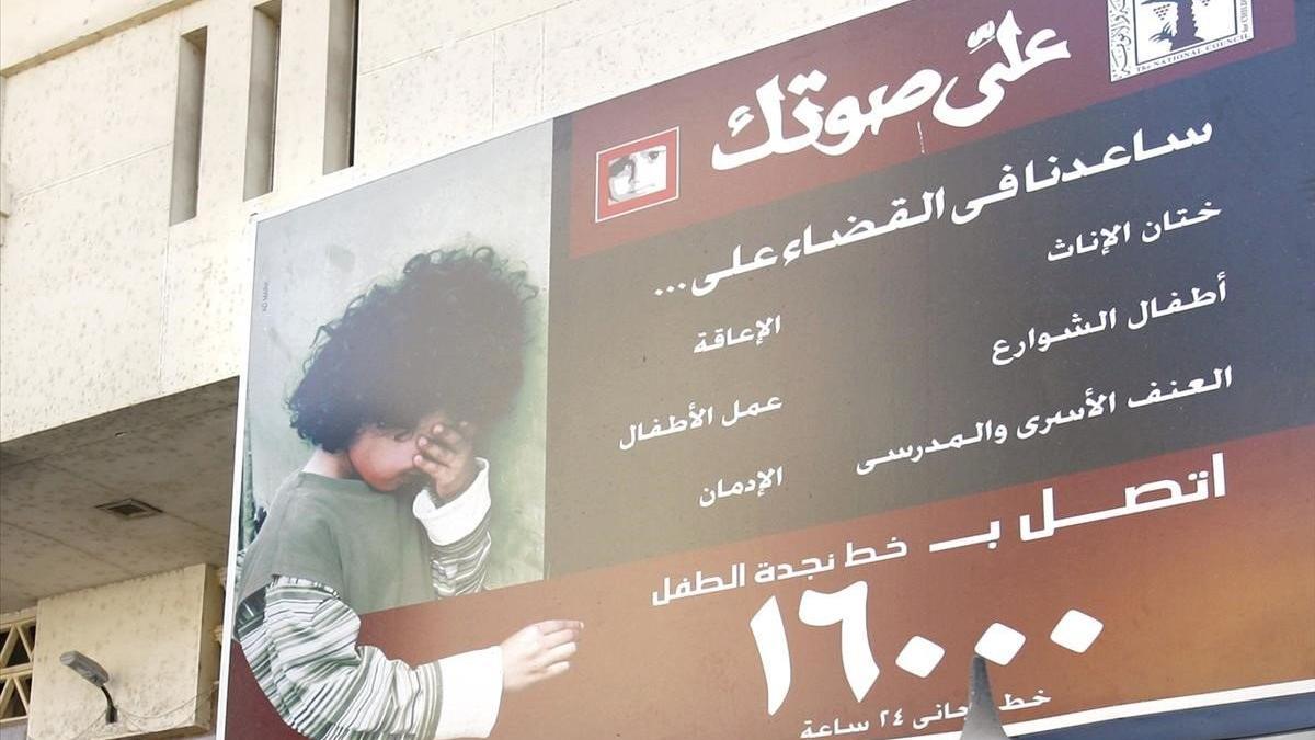 Una valla publicitaria alienta a las familias a que dejen de mutilar los genitales de sus hijas, en el exterior de la estación de trenes de la ciudad egipcia de Minya.