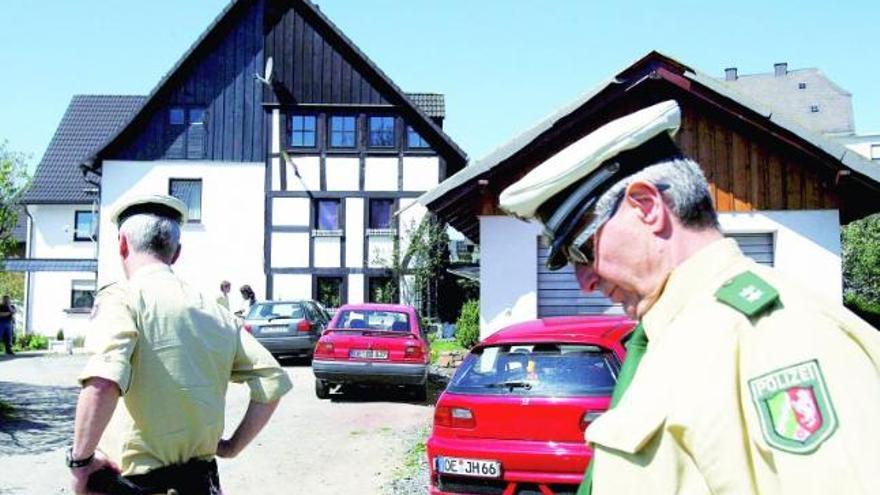 Dos policías, ante la casa en la que aparecieron tres bebés en un congelador, al oeste de Alemania.