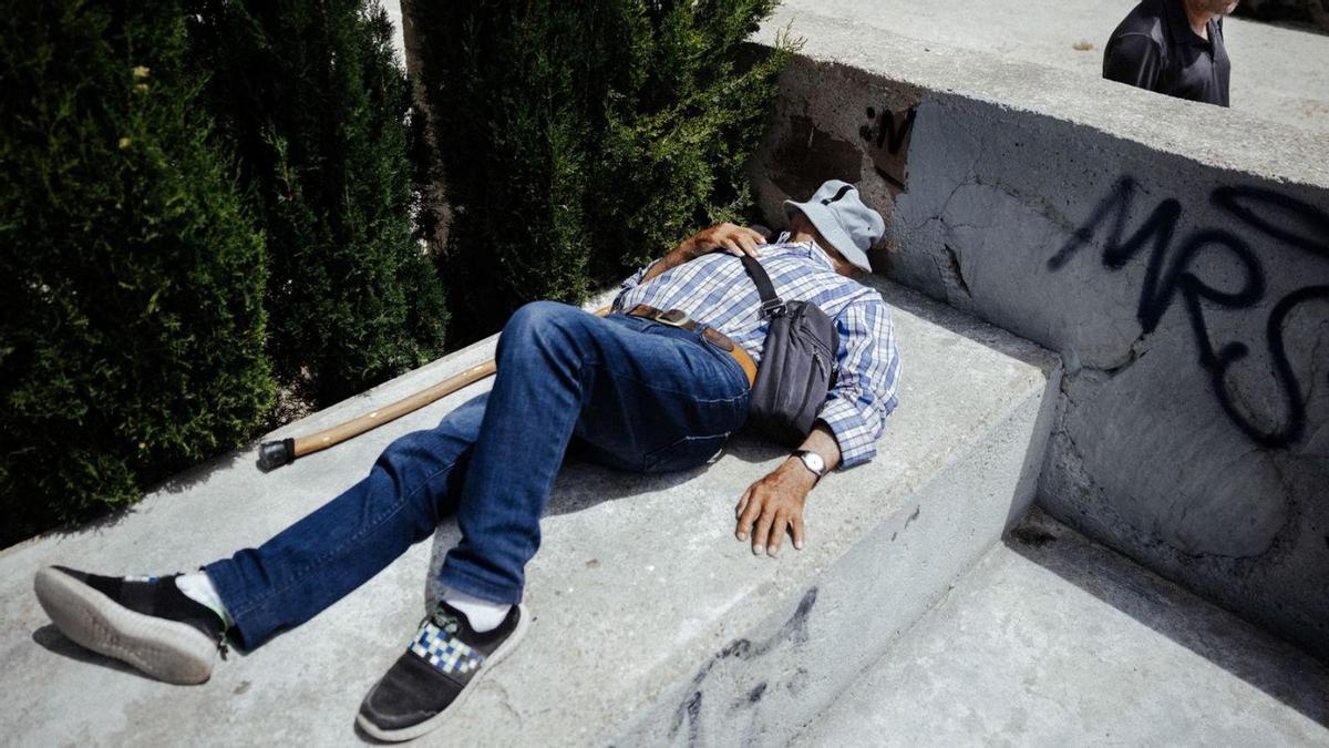 Un hombre se echa una cabezada en un parque.
