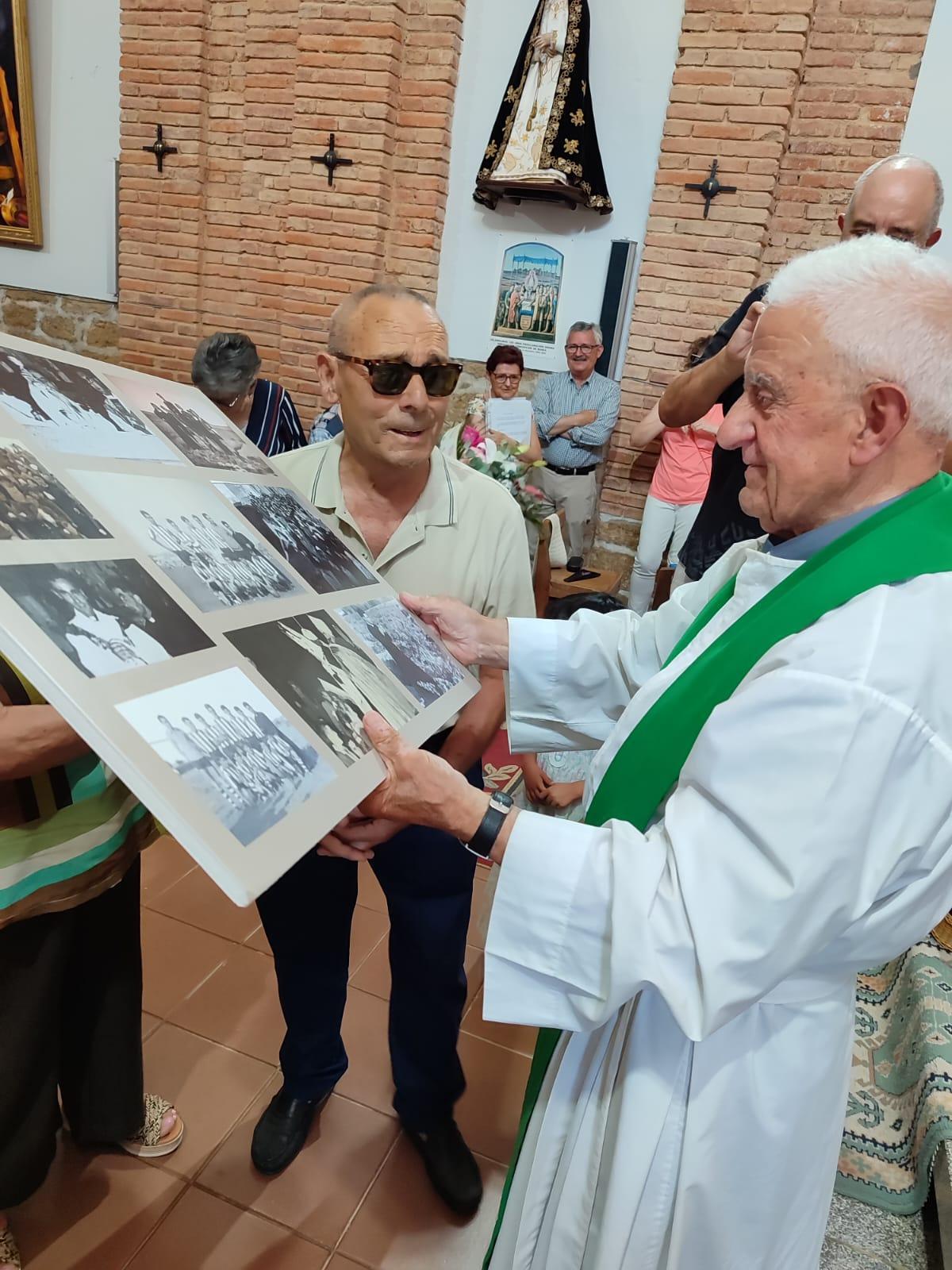 El párroco recibe un cuadro con fotografías antiguas sobre su primera etapa en el pueblo.