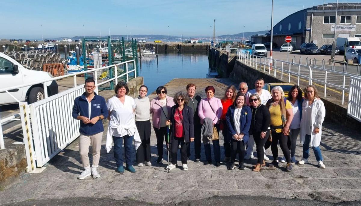 Sanitarios y vecinos durante una parada en la caminata de ayer, a la altura del puerto de Bueu.