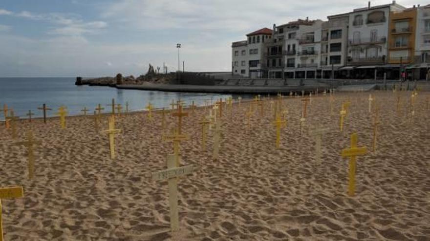 La platja, plena de creus grogues amb lemes de «Llibertat», «Democràcia» i «República».