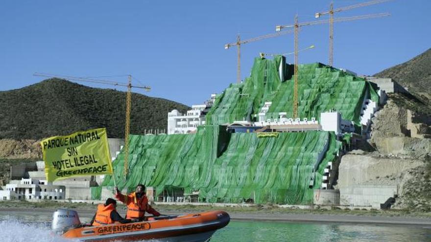 Sesenta activistas de Greenpeace se han trasladado hoy al paraje de El Algarrobico para cubrir el polémico hotel que promueve Azata con una tela verde de 18.000 metros cuadrados en una acción de protesta que persigue forzar al Ministerio de Medio Ambiente a que &quot;derribe ya&quot; el edificio.