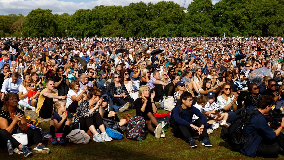 La gente mira en las pantallas el día en que el ataúd de la reina Isabel de Gran Bretaña es transportado desde el Palacio de Buckingham a las Casas del Parlamento para su deposición, en Hyde Park, en Londres.