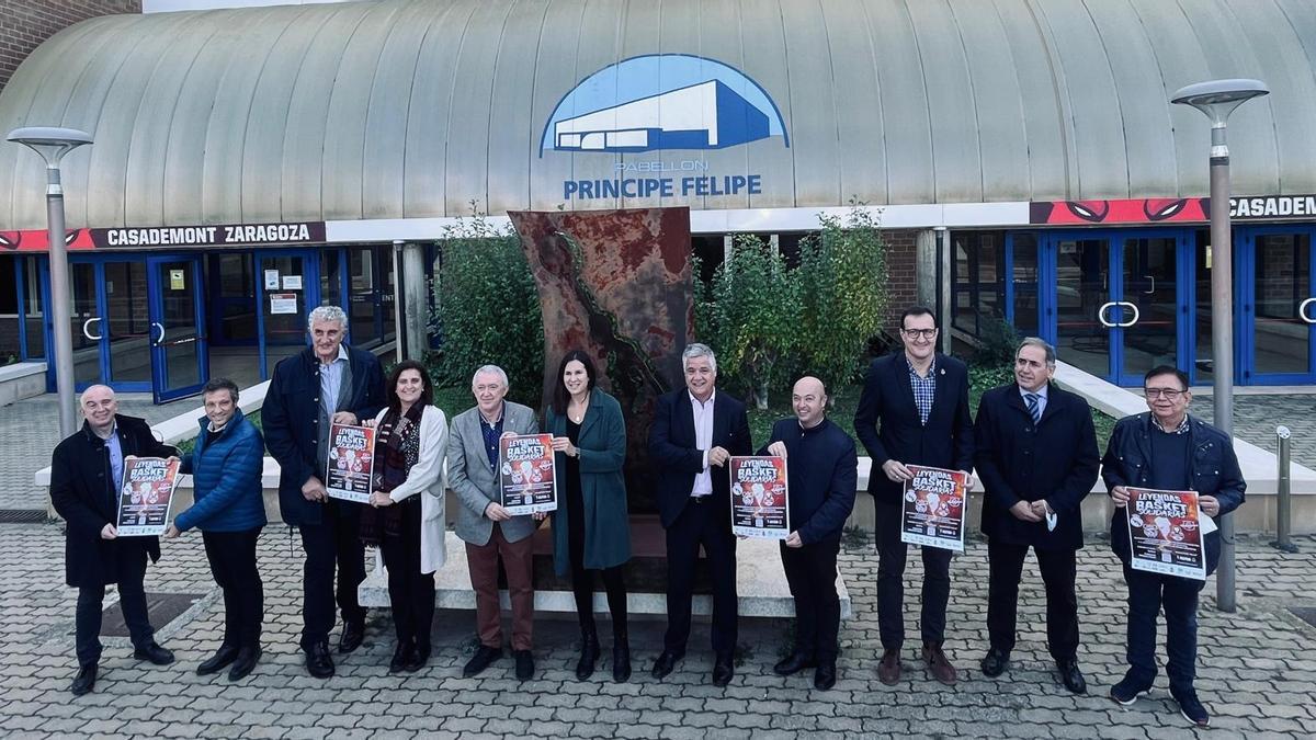 Los representantes políticos y deportivos posan con el cartel de presentación del evento a las puertas del Príncipe Felipe