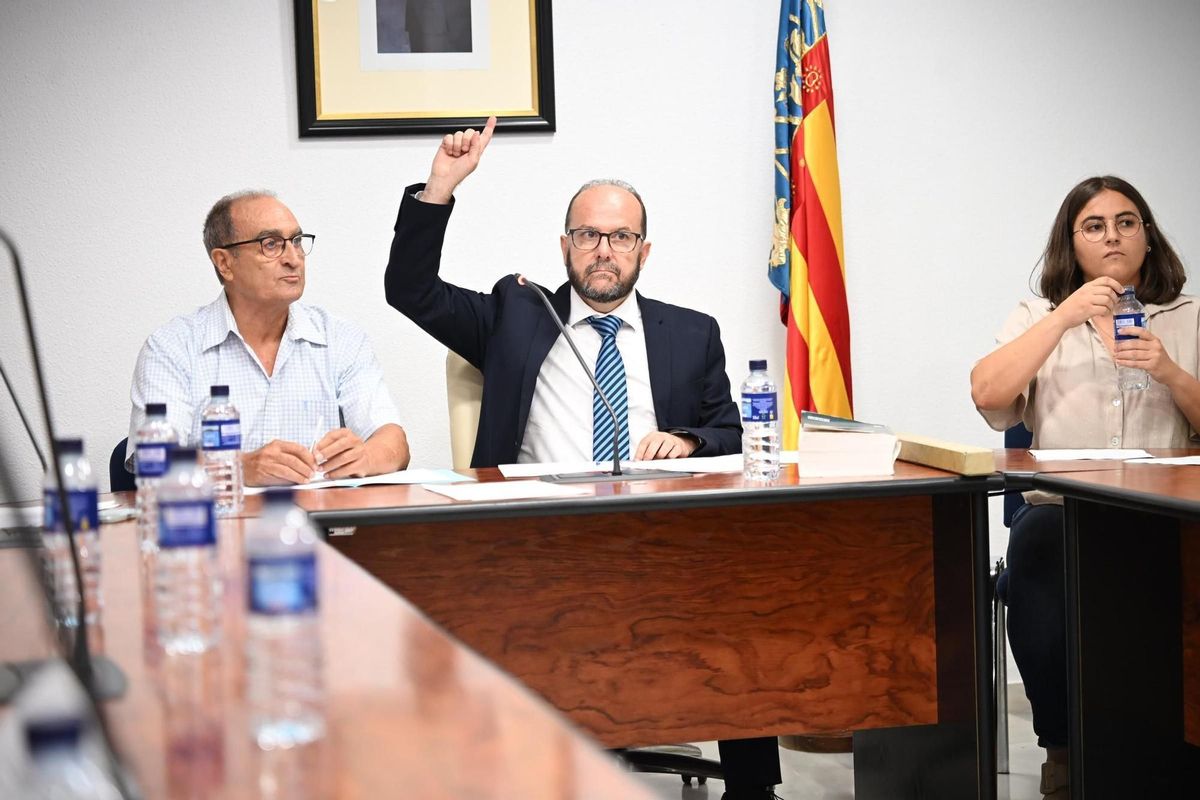 El secretario del pleno levanta la mano para poder intervenir en el pleno flanqueado por la mesa de edad del pleno de moción de censura en San Fulgencio formada por dos ediles del PP
