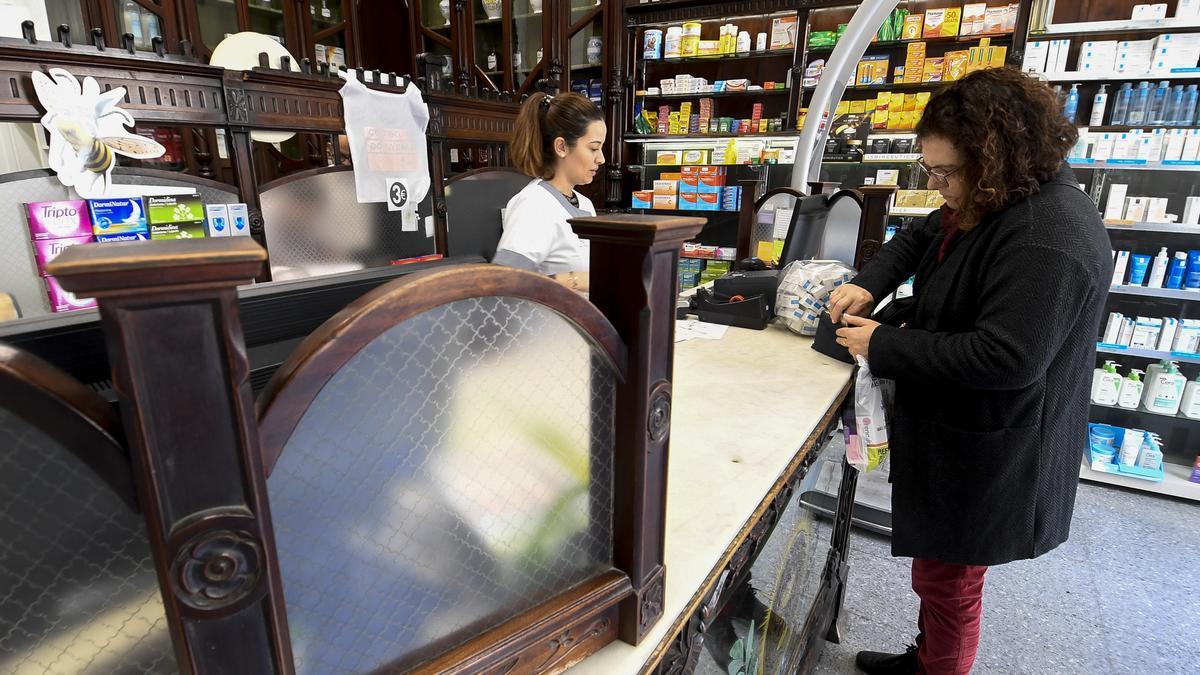 Una mujer compra varios medicamentos en su farmacia.