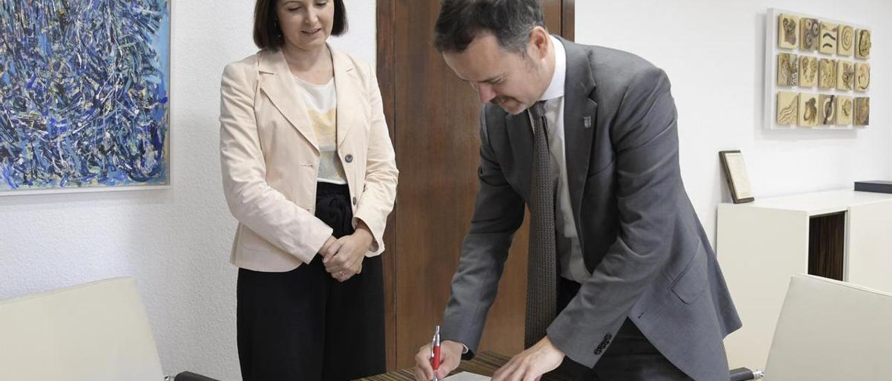 Pablo Gil, cónsul honorario de Ucrania, firma en el libro de honor del consistorio de Paiporta junto a la alcaldesa, Maribel Albala.