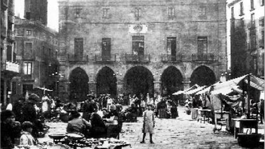 El mercat a la plaça Major, en una imatge de l&#039;any 1900. La Seu encara està coronada en punxa