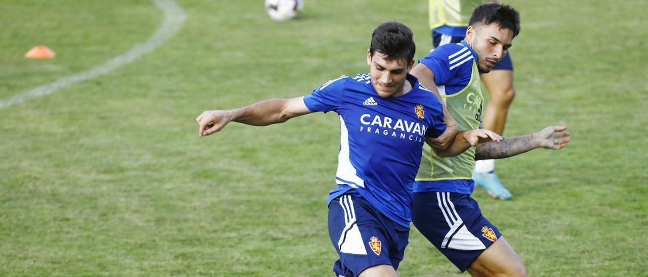 Iván Azón pugna por el balón con Lluís López durante un entrenamiento.