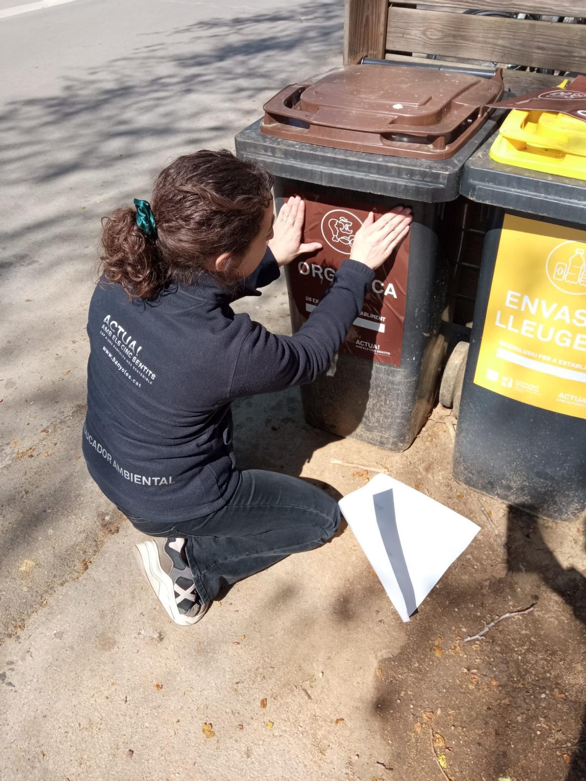 Una de les educadores ambientals que han dut a terme campanyes informatives als comerços de Banyoles per fomentar el reciclatge.