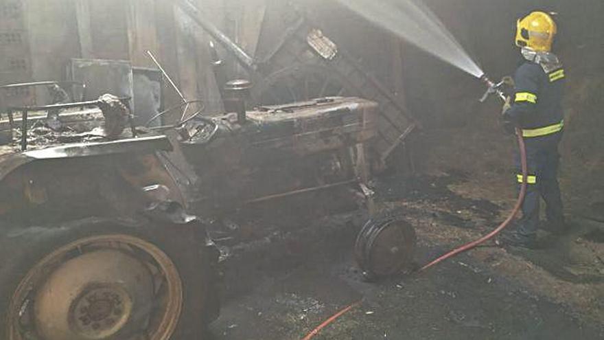 Un bombero termina de sofocar el incendio surgido ayer en una nave agrícola de Puercas de Aliste.