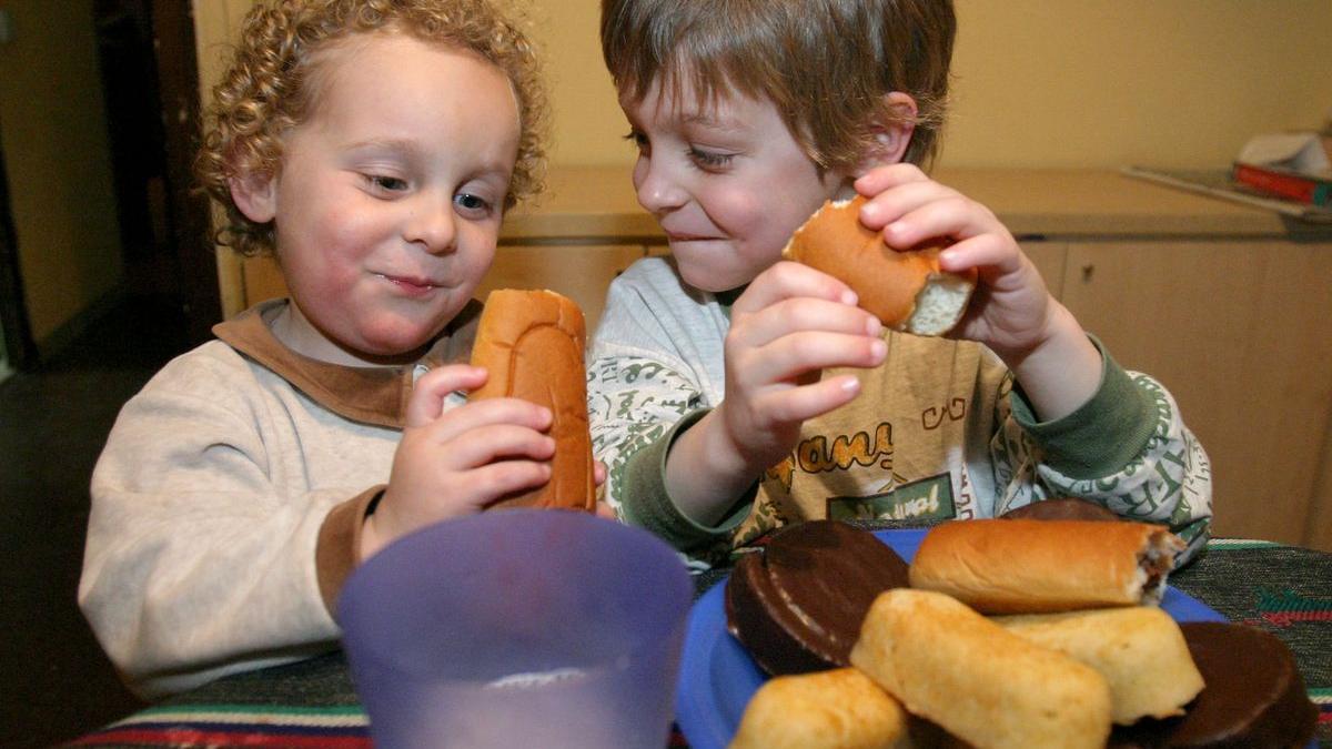 Dos niños comiendo bollería.