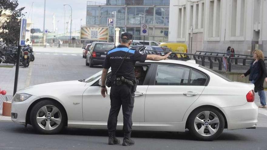 Un agente de la Policía Local de A Coruña da indicaciones a un conductor.