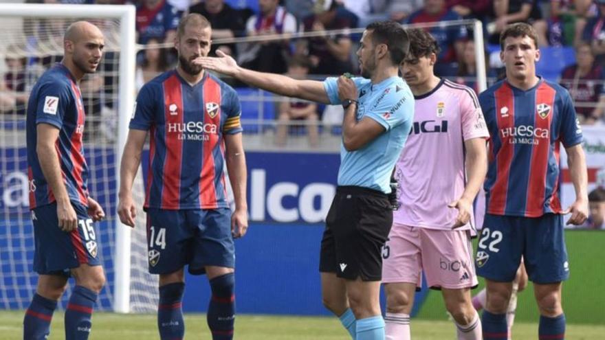 El árbitro González Francés explica a los jugadores del Huesca por qué no pitó penalti.