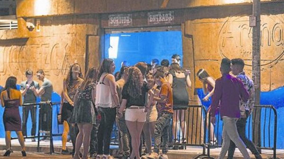 Jóvenes concentrados ante la puerta de acceso a la discoteca Arena de Blanes, la madrugada del domingo.