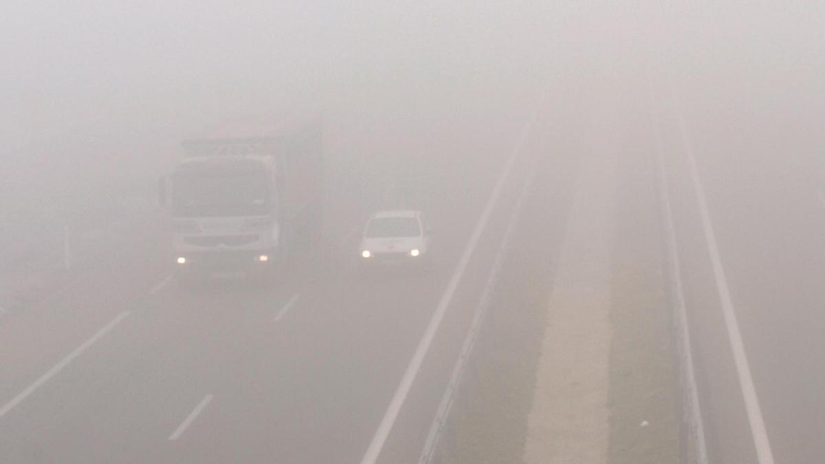 Un camión y un coche circulan con niebla en la A2, en dirección a Lleida.