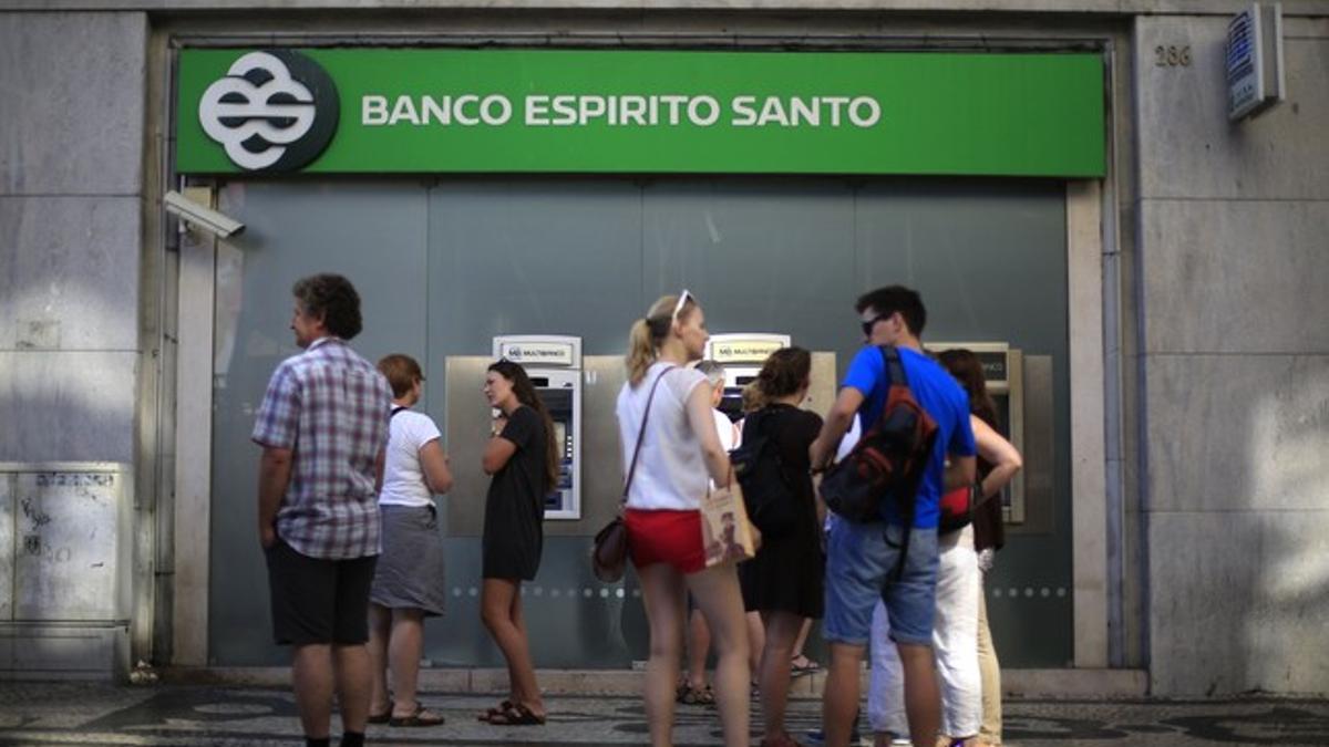 Personas extraen dinero de cajeros automáticos del banco Espírito Santo, el pasado 22 de julio.