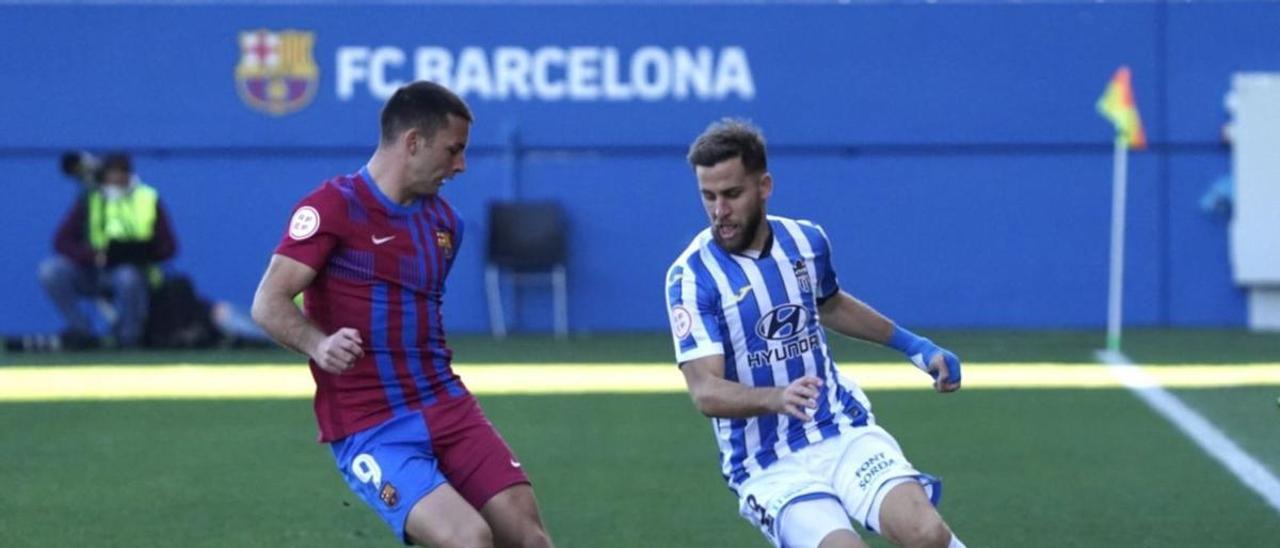 El centrocampista balearico Cordero pugna por un balón con el mallorquín Rodado, delantero del Barcelona B.