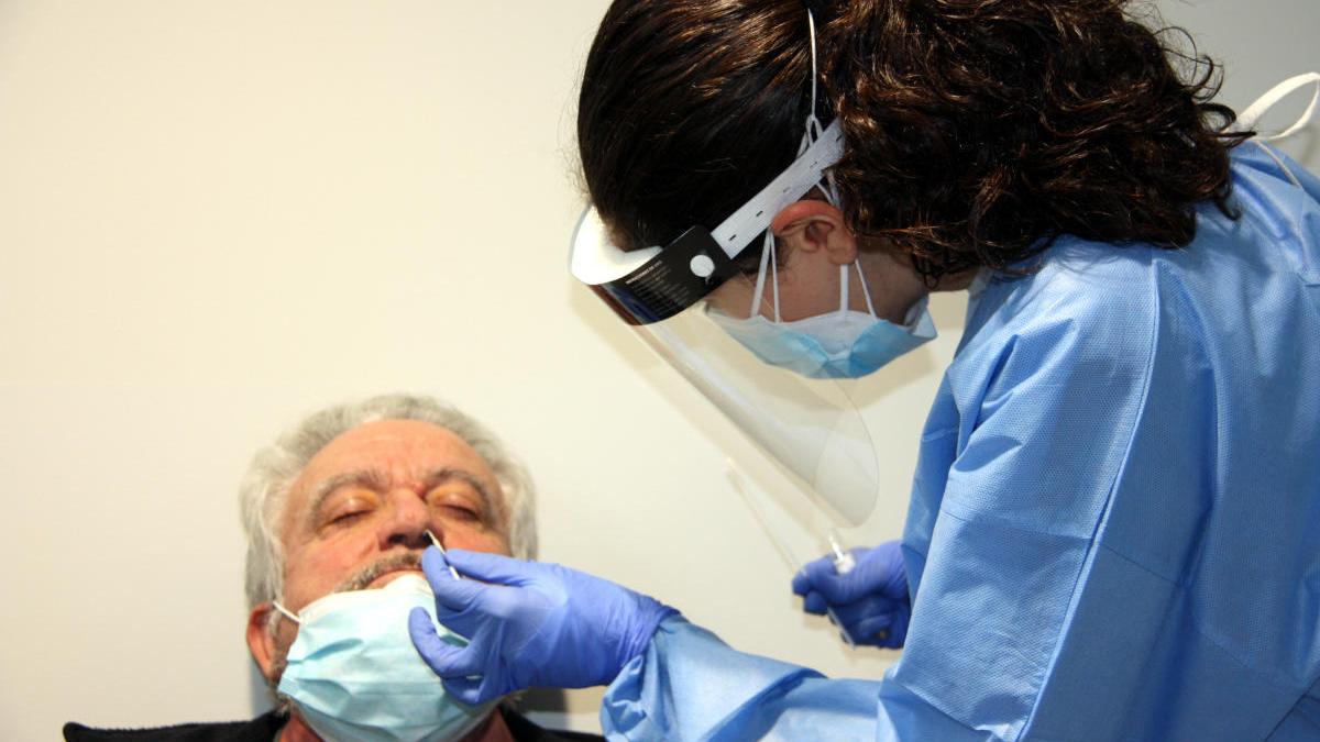 Primer pla d&#039;una sanitària realitzant una PCR a un pacient.