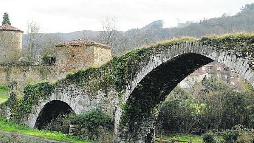 Puente medieval de Olloniego, con el palacio y la torre de Quirós a la izquierda.