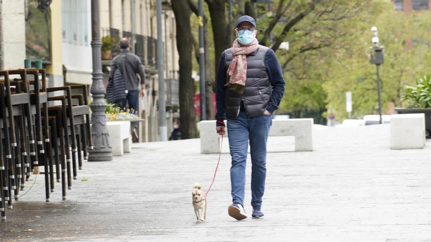 Un home passejant un gos a Girona