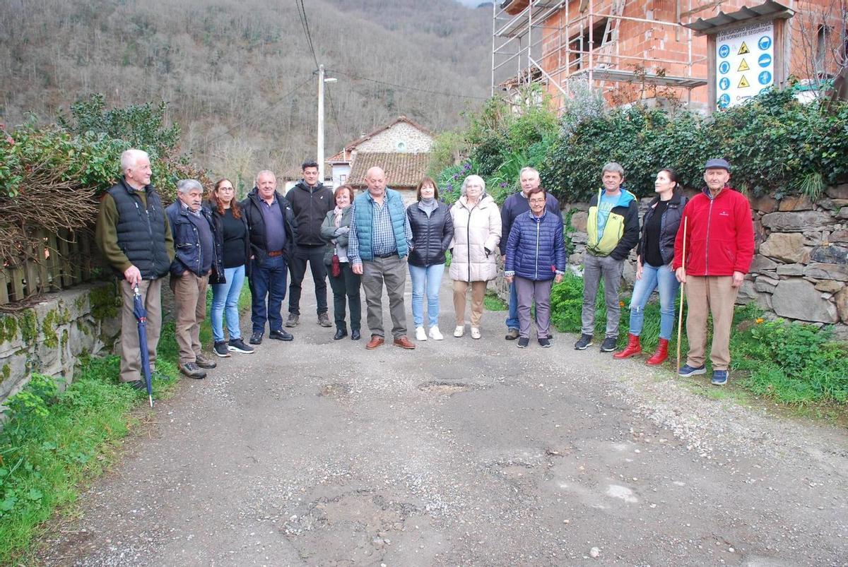 Vecinos de Abiegos en la travesía de la localidad, repleta de baches.