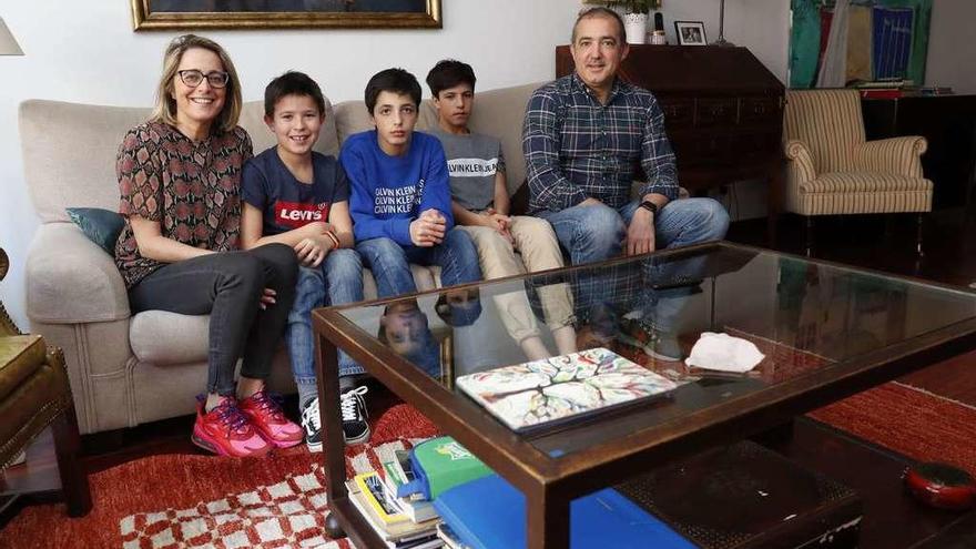 Raquel Pérez y Álvaro Martínez-Herrera, con sus tres hijos Álvaro, Juan y Miguel en el salón de su casa en Vigo. // José Lores