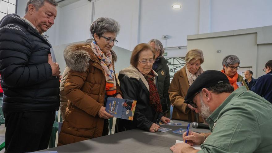 Ameixeiras firmando ejemplares de «O noso mar no teu prato» ayer en la Plaza de Abastos. | Iñaki Abella
