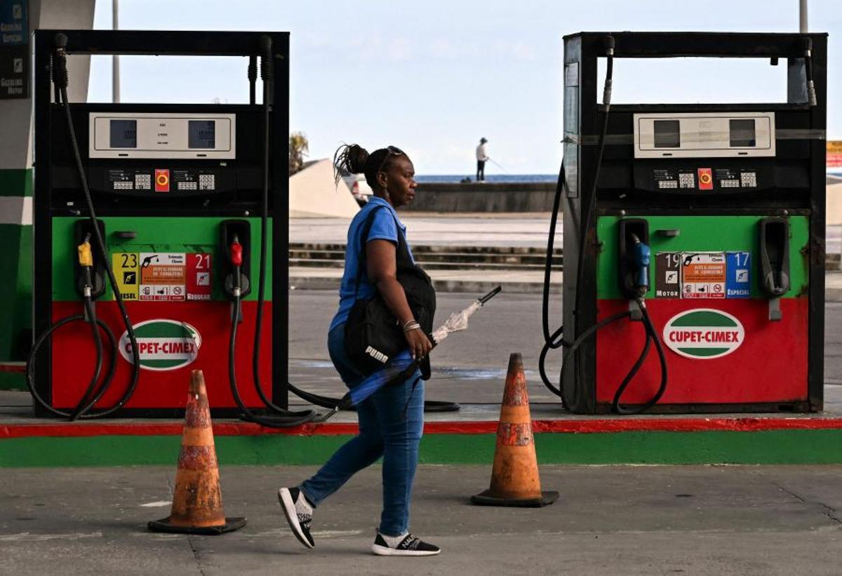 Una mujer camina frente a una gasolinera vacía en La Habana, Cuba, el 15 de mayo de 2026. Desde esa fecha, Cuba implementa precios variables para el combustible vendido en moneda extranjera, una medida destinada a afrontar el aumento de los costes de importación. Los precios en las estaciones de servicio pueden fluctuar en función de factores como proveedores, fletes, rutas de suministro, seguros y la volatilidad del mercado global, lo que permite la coexistencia de distintos precios según los costes operativos.
