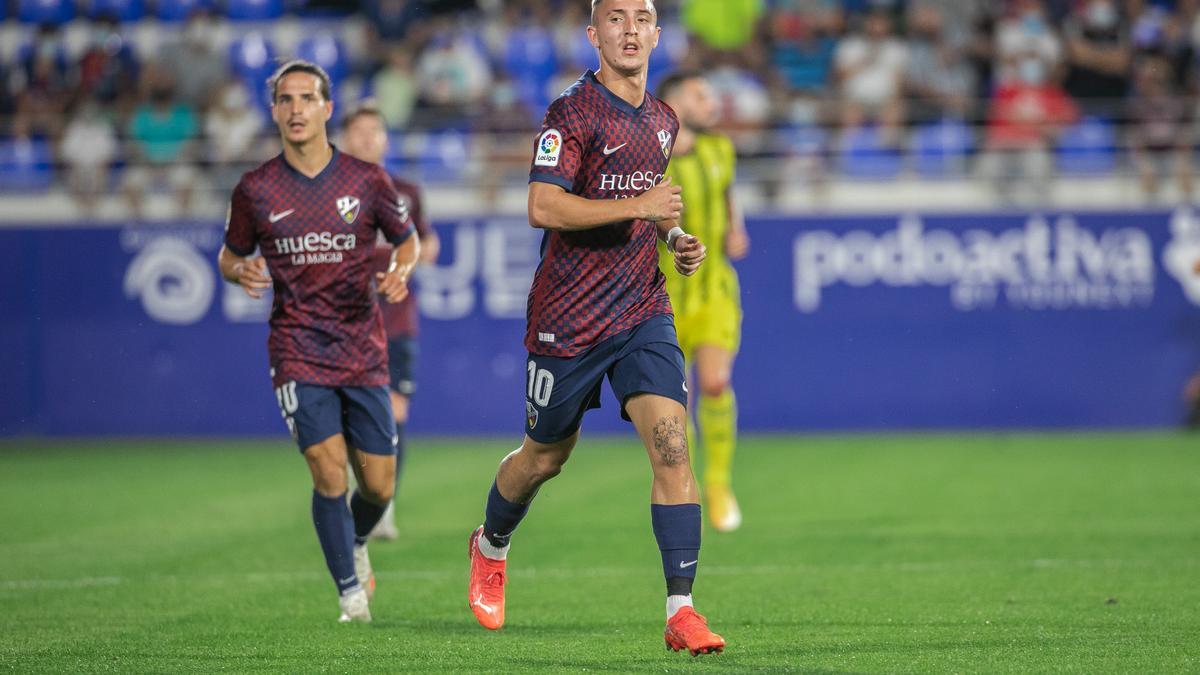 Escriche, con Seoane a su espalda, en un partido de esta temporada con el Huesca.