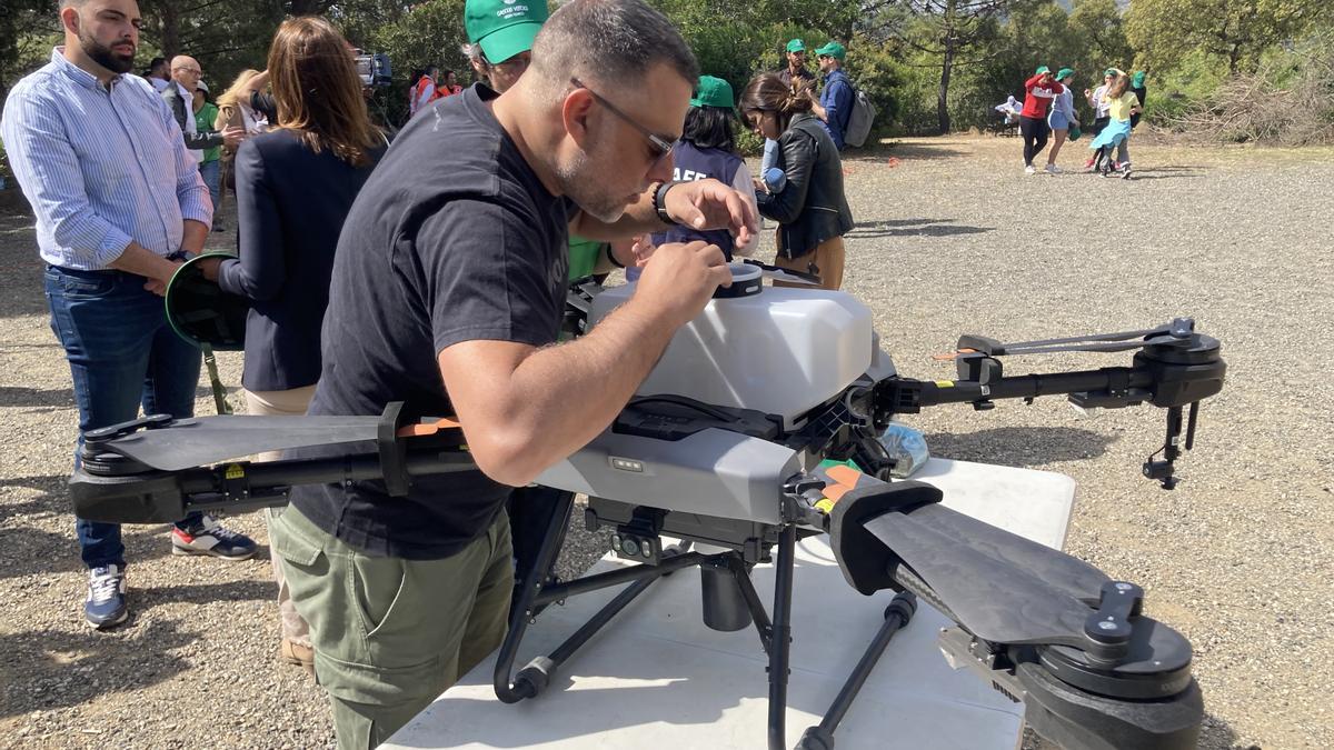 Un técnico prepara un dron para lanzar las bombas de semillas.