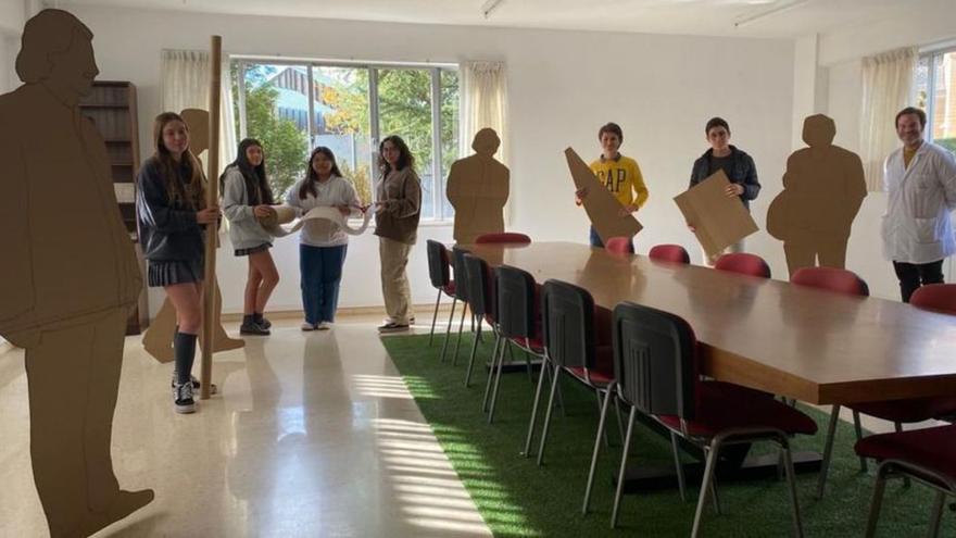 Valentina García, Beatriz García, Madeling Scarlet González, Irene García-Pumarino, Guzmán Macías, Suso Fernández y Alfredo Estébanez, entre las siluetas en cartón de Shigeru Ban instaladas en la sala de profesores del Auseva, en Oviedo. | LNE