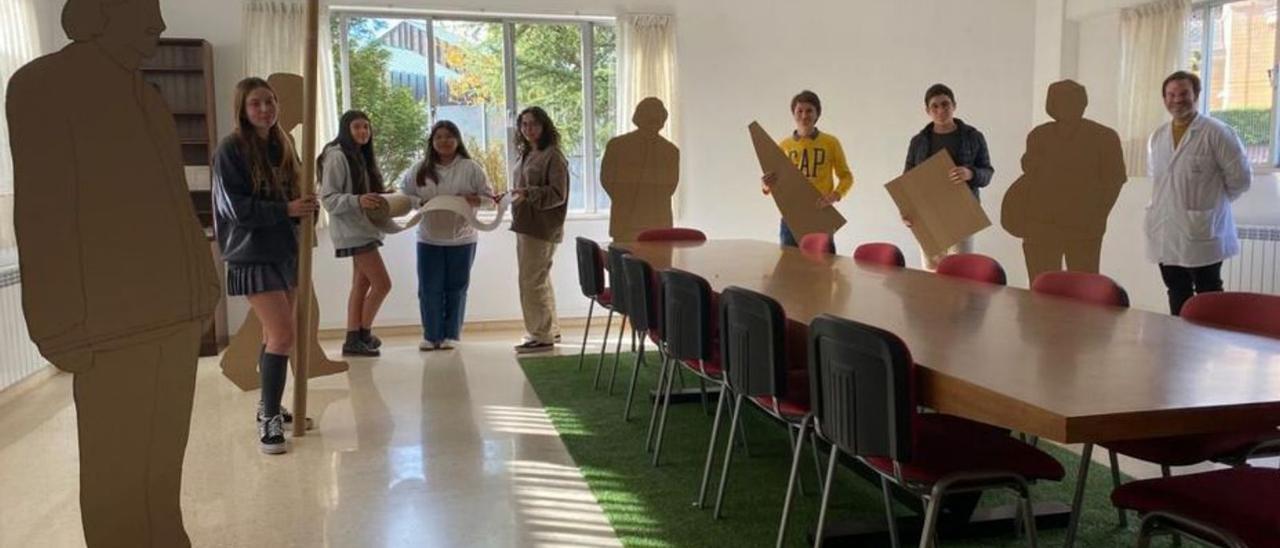 Valentina García, Beatriz García, Madeling Scarlet González, Irene García-Pumarino, Guzmán Macías, Suso Fernández y Alfredo Estébanez, entre las siluetas en cartón de Shigeru Ban instaladas en la sala de profesores del Auseva, en Oviedo. | LNE