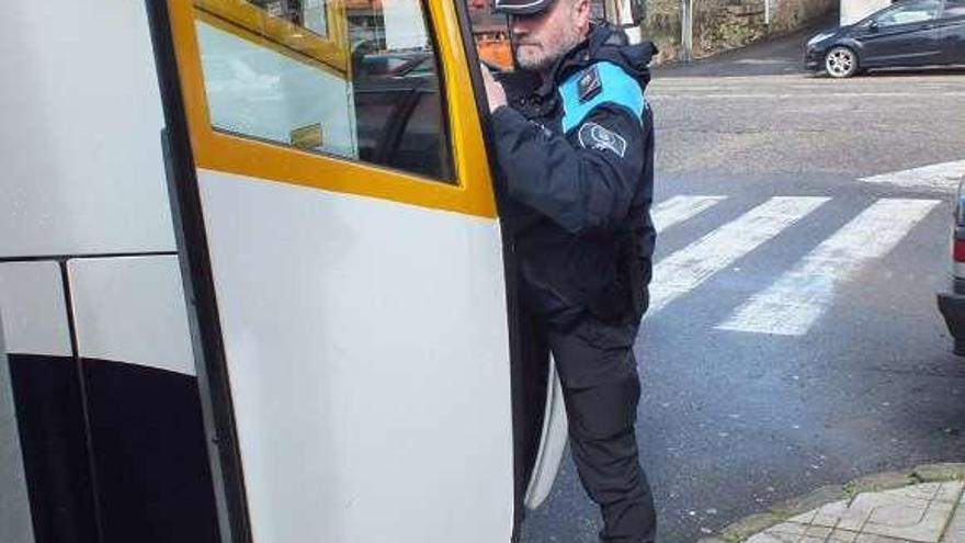 Un policía porriñés revisando uno de los autobuses.  // D.P.