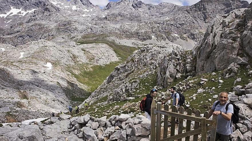 Por la derecha, Santiago Parrado, Miguel Iglesias y Jesús Pérez, en la bajada a la vega de Liordes, al fondo. | Miki López