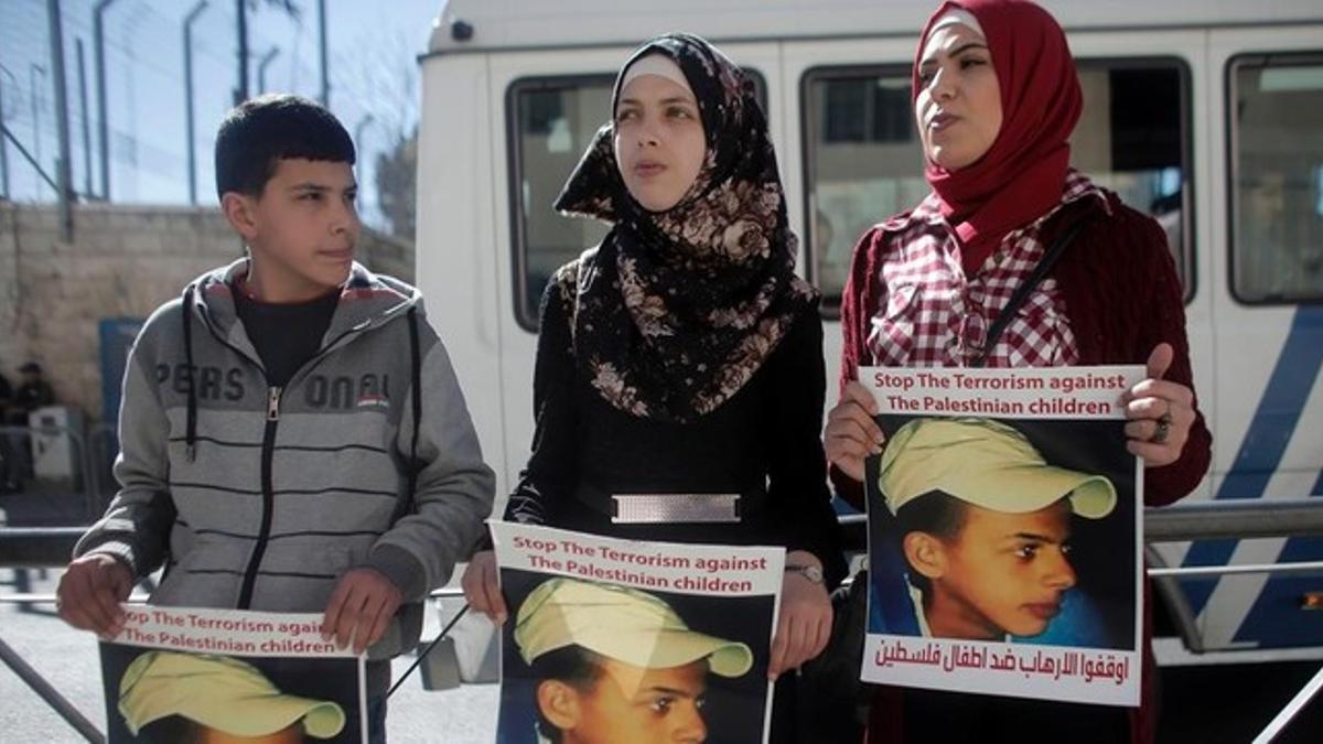 Los familiares del adolescente palestino Mohamed Abu Jdeir que murió en 2014, muestran su retrato en el exterior de la Audiencia en Jerusalén.