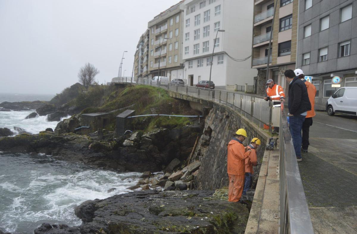 Los operarios, en el muro donde se abrió el boquete.