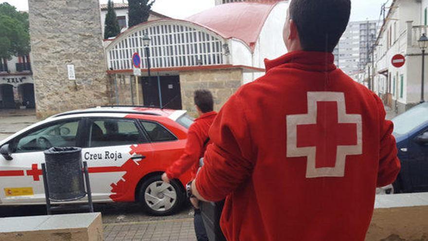 Voluntaris de la Creu Roja amb un bagul amb menjar a Blanes