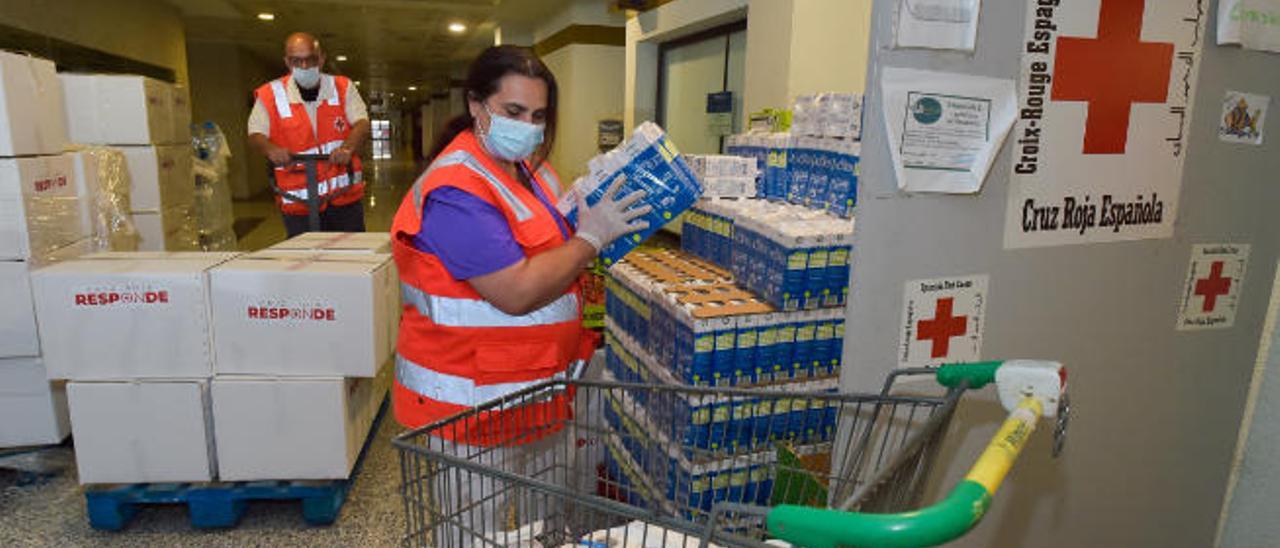 Voluntarios de Cruz Roja preparan alimentos y enseres de primera necesidad durante el confinamiento.