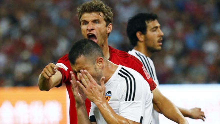 Müller celebra su gol ante un jugador del Valencia.