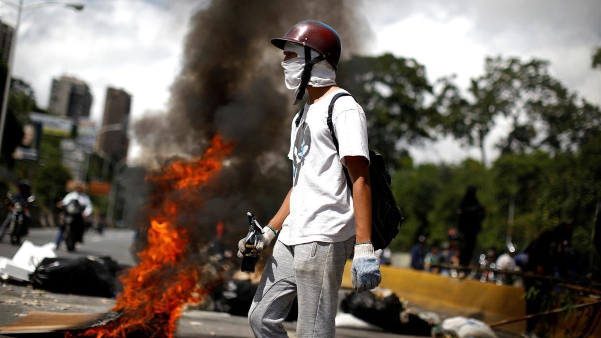 Un manifestante frente a una barricada durante la huelga, en Caracas, el 26 de julio.