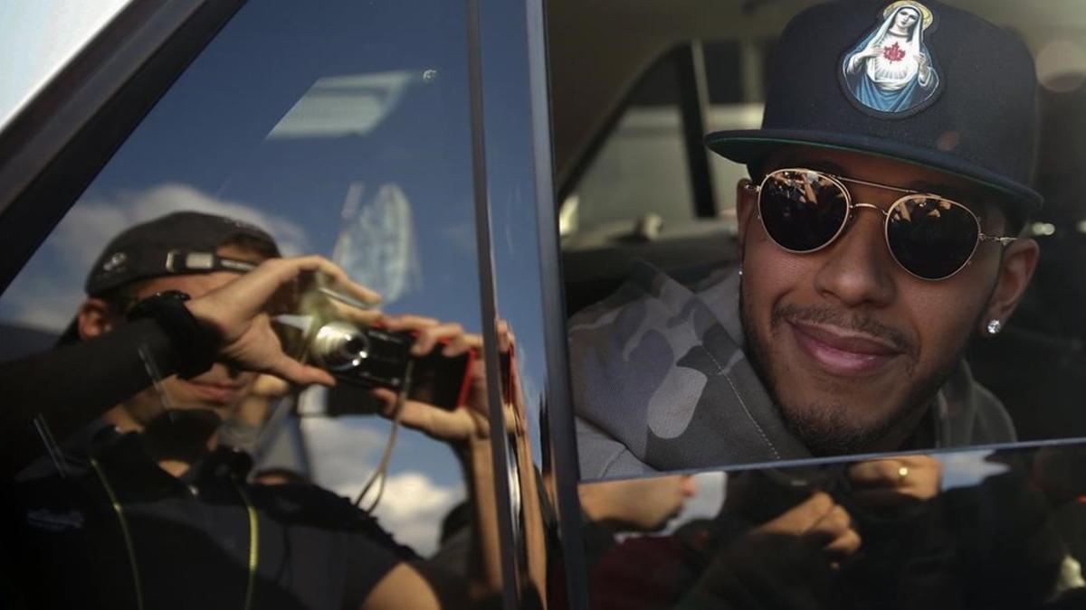 Lewis Hamilton posa para una foto dentro de un coche.