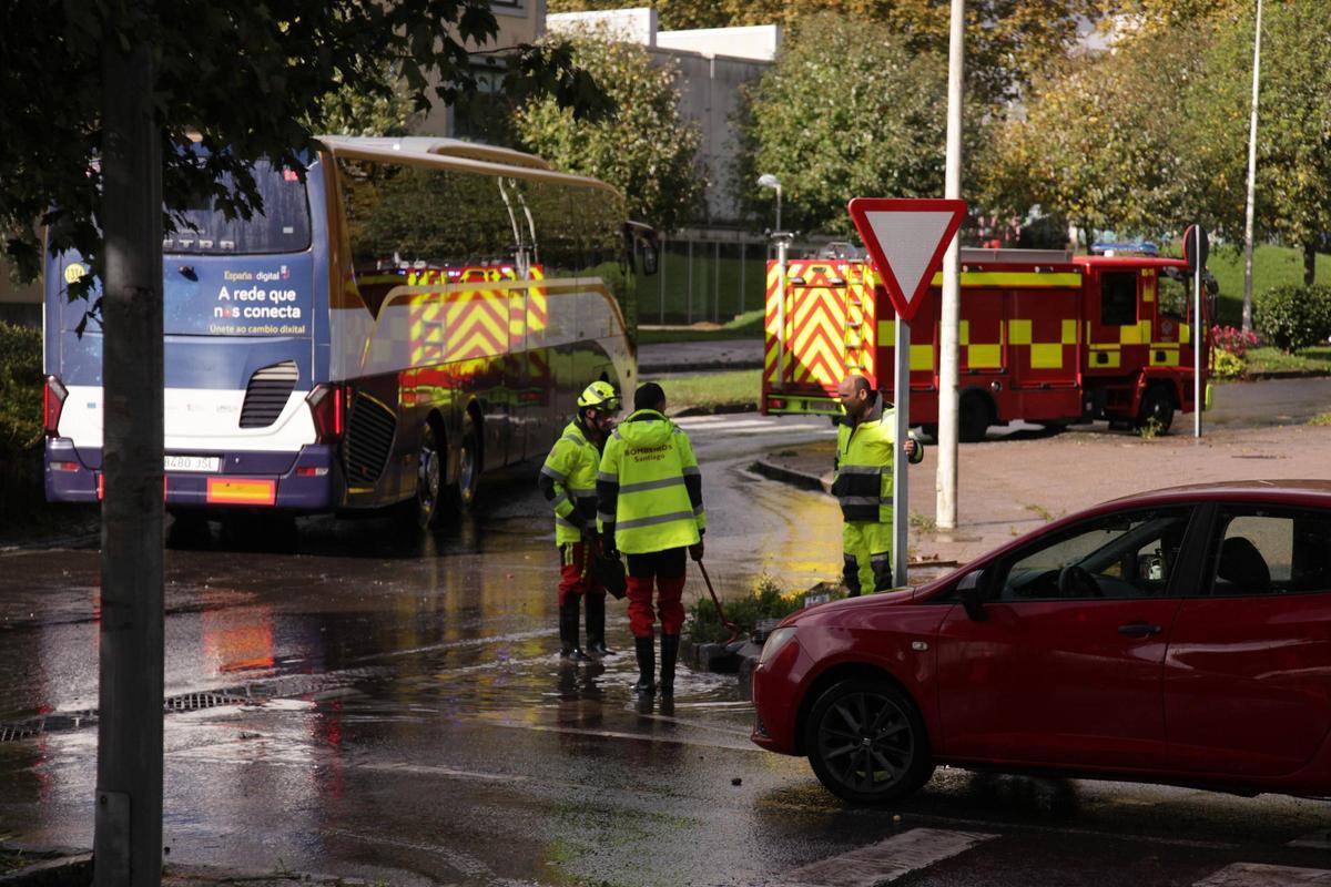 Bomberos de Santiago desatascando las alcantarillas en la rotonda del Multiusos do Sar que este jueves ha vuelto a registrar balsas de agua