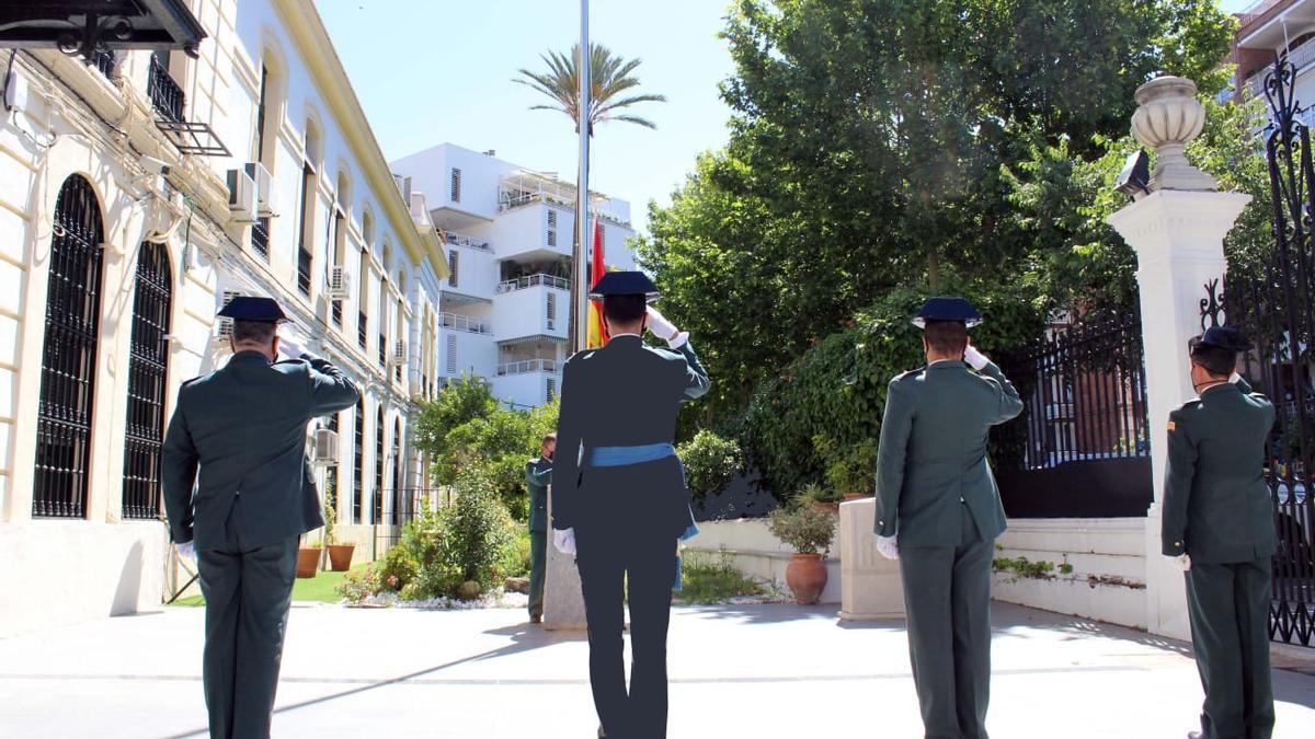 Varios guardias en posición de saludo ante a la bandera, izada en la Comandancia de Córdoba durante el acto de conmemoración de los 177 años de la fundación de la Benemérita.