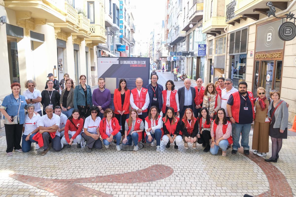 Voluntarios y personal de Cruz Roja y varios ediles posan junto a uno de los paneles.