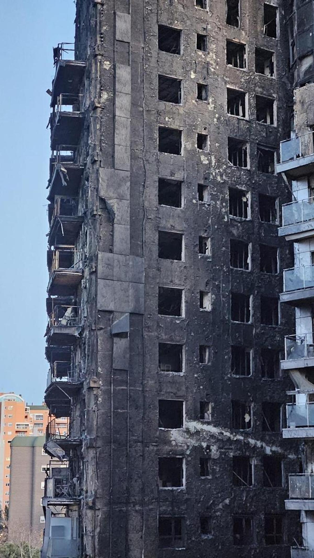 Imagen del edificio quemado, con las placas nuevas, a la derecha.