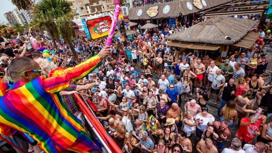 Cientos de personas aplauden el paso de unas de las carrozas participantes en el desfile central del Benidorm Pride del pasado año, en la primera línea de la playa de Levante.