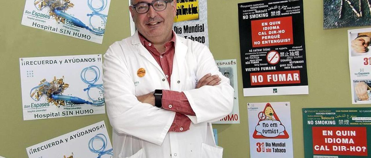 El doctor Jaume posa junto al cartel, a su derecha, galardonado ayer como el mejor para disuadir de fumar.